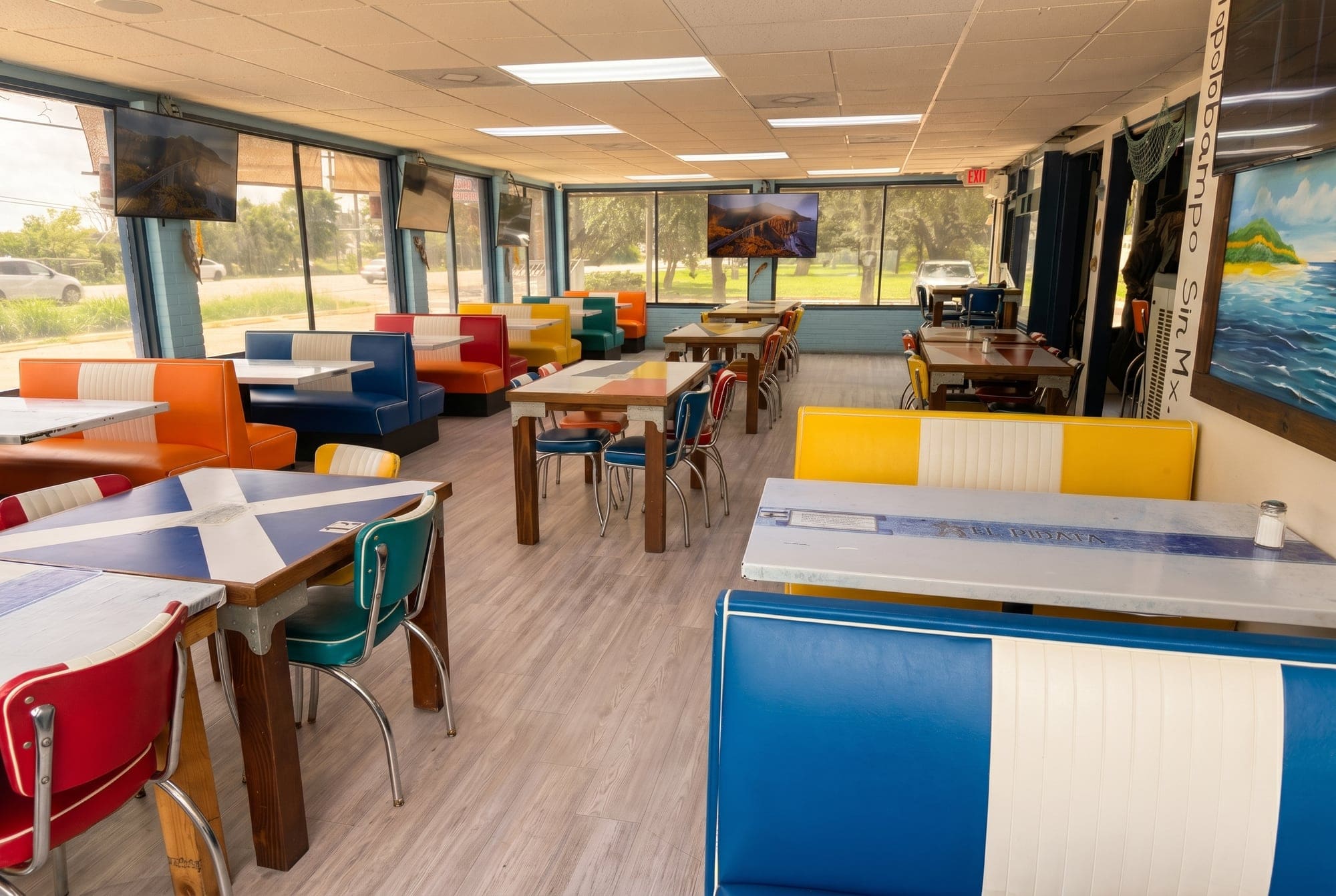 Dining room with white and blue booths and sunny windows