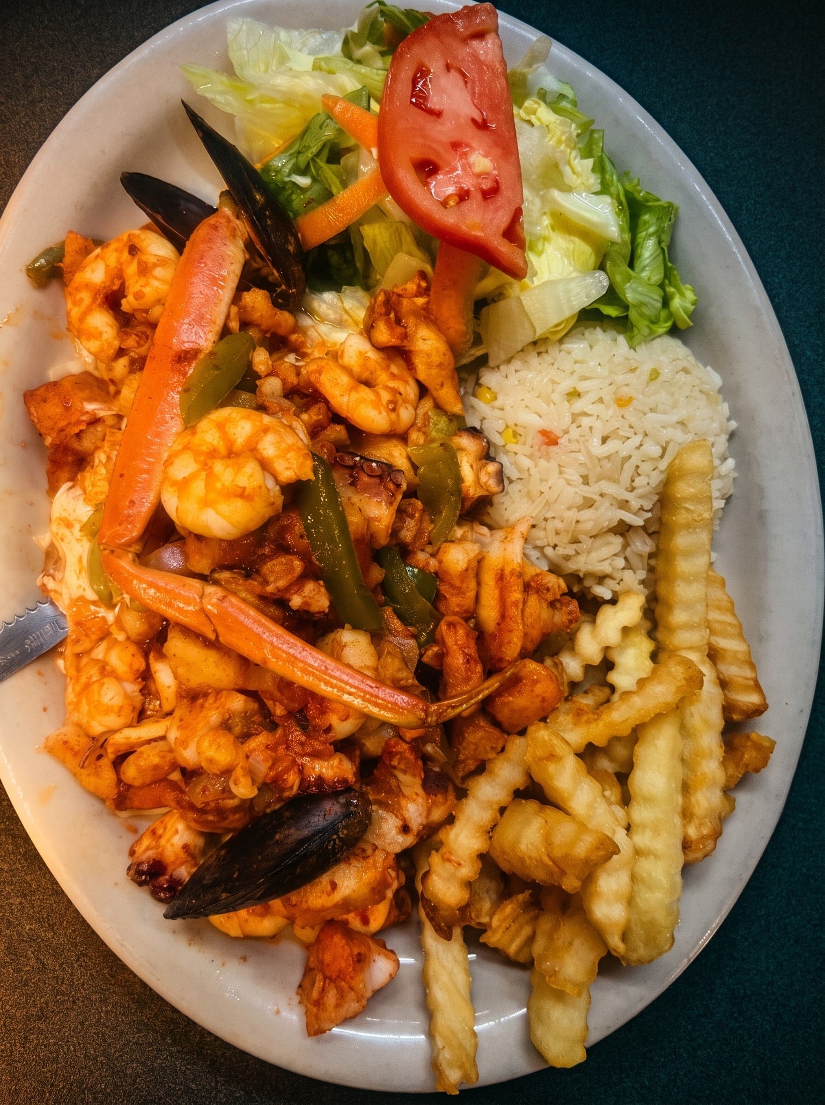 Platillo caliente de mariscos con arroz, papas y ensalada