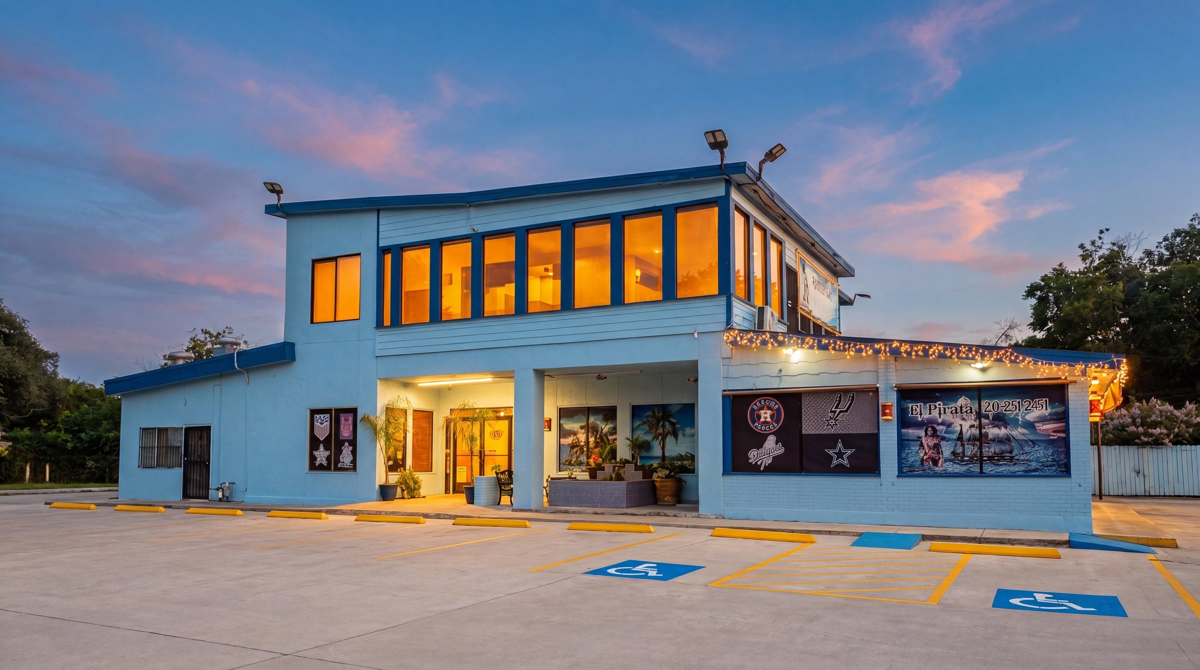 El Pirata Seafood Mexican Foodbar at dusk — light-blue building with glowing windows on S WW White Rd