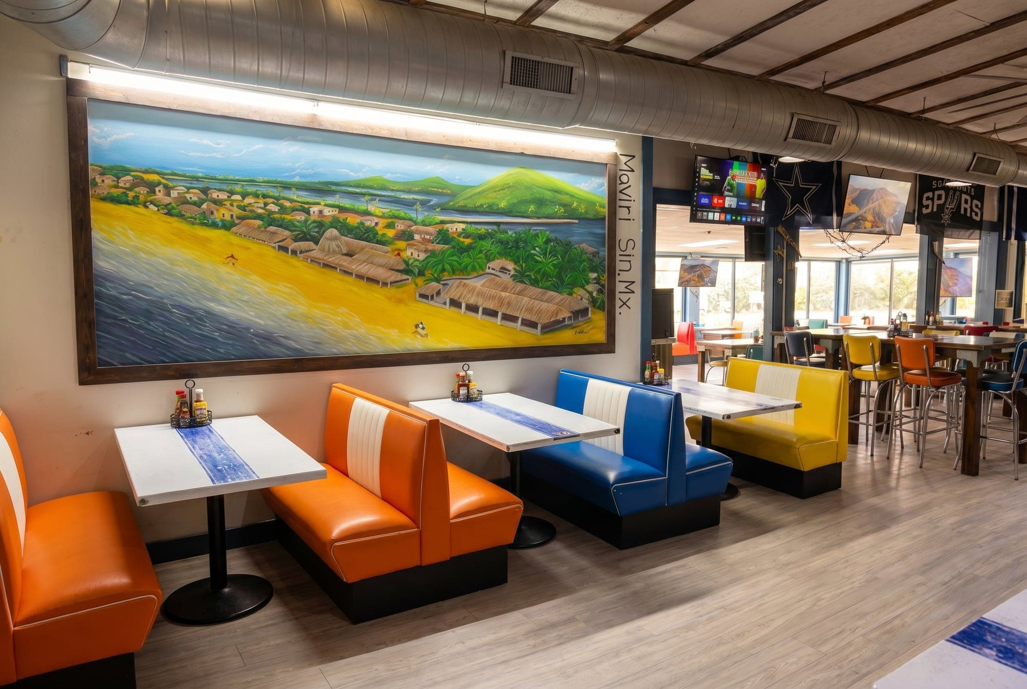 Hand-painted mural over orange and blue booths