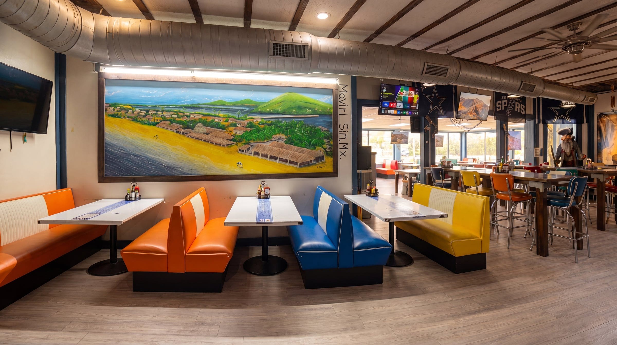 The full room — hand-painted mural and colorful booths inside El Pirata, uncropped
